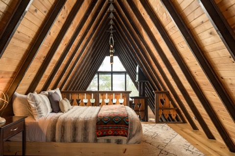 The loft bed tucked under the A-frame's peak.