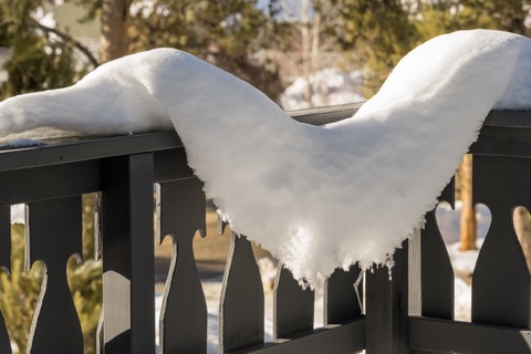 Deep snow curled over the deck railing.