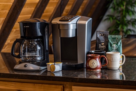Coffee makers and mugs on the kitchen counter.