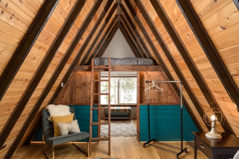 The loft's peaked ceiling with a ladder.