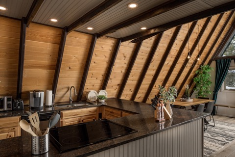 The kitchen island beneath the sloped wood ceiling.