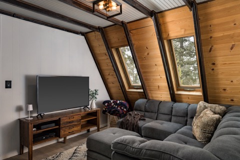 The great room's couch and TV under the beamed ceiling.