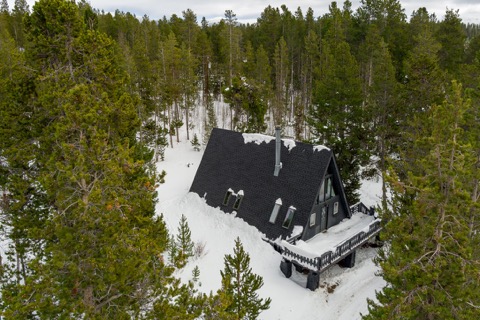 The A-frame from above, alone among the pines.