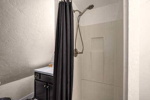 The bathroom's shower stall and vanity.