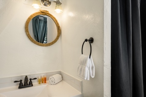 The bathroom sink with a rope-framed mirror.