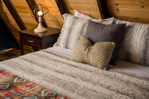 Pillows and a nightstand lamp in the loft.